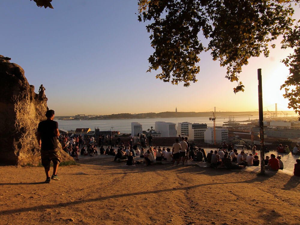 People gathered to watch the sunset at Miradouro de Santa Catarina.