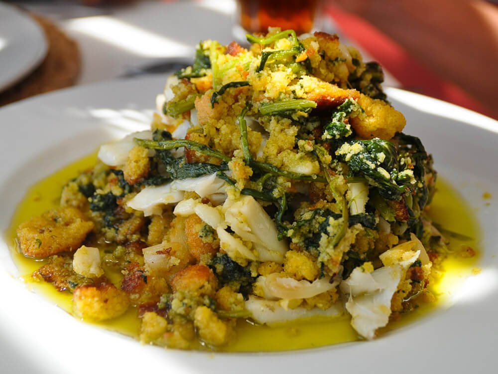 A plate of shredded codfish with onions and plenty of olive oil.