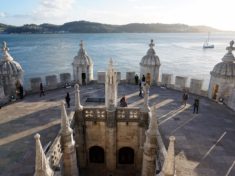 A stunning view from the top of the Belém Tower, featuring its iconic turrets and the Tagus River in the background.