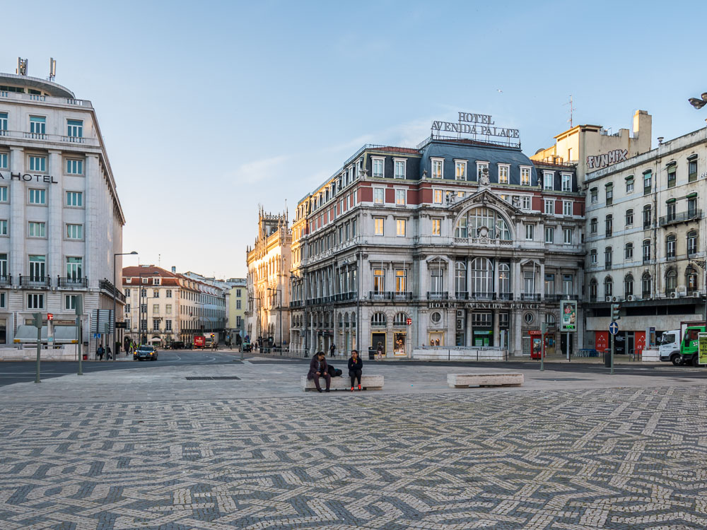 Hotel Avenida Palace in Lisbon, a stately building with a mix of neoclassical and beaux-arts architectural styles, illuminated by the soft morning light.