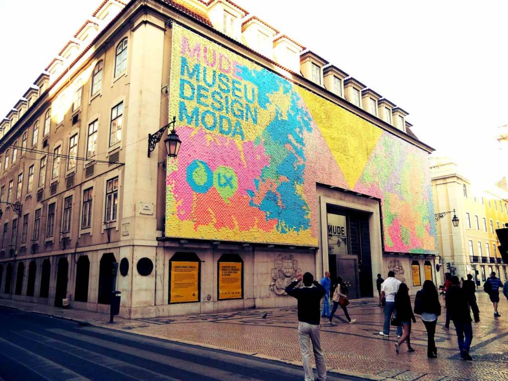  The MUDE, Museu do Design e da Moda, a contemporary design museum in Lisbon. The building's facade is adorned with a vibrant and colorful mural, attracting visitors walking by.