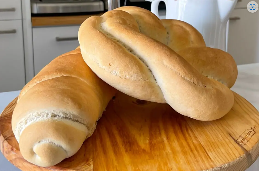 Two breads on a round wooden board.