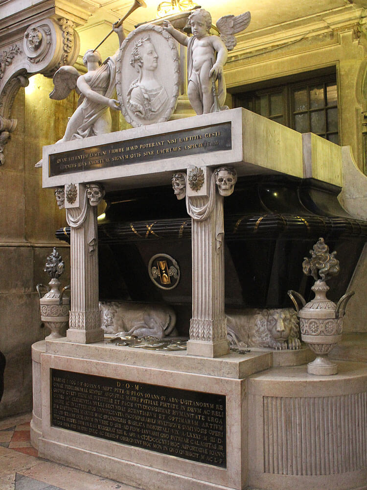 A detailed view of a tomb with ornate carvings and statues.