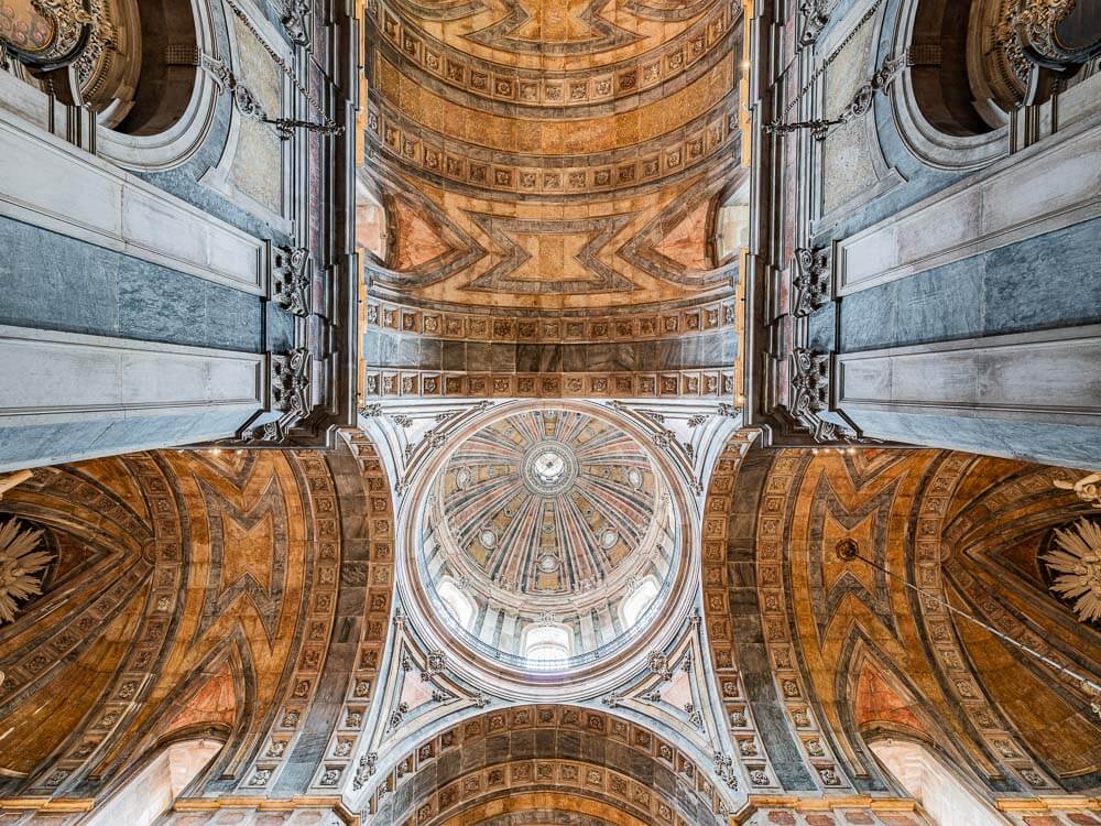 The ornate ceiling and dome inside Basílica da Estrela, viewed from directly below.