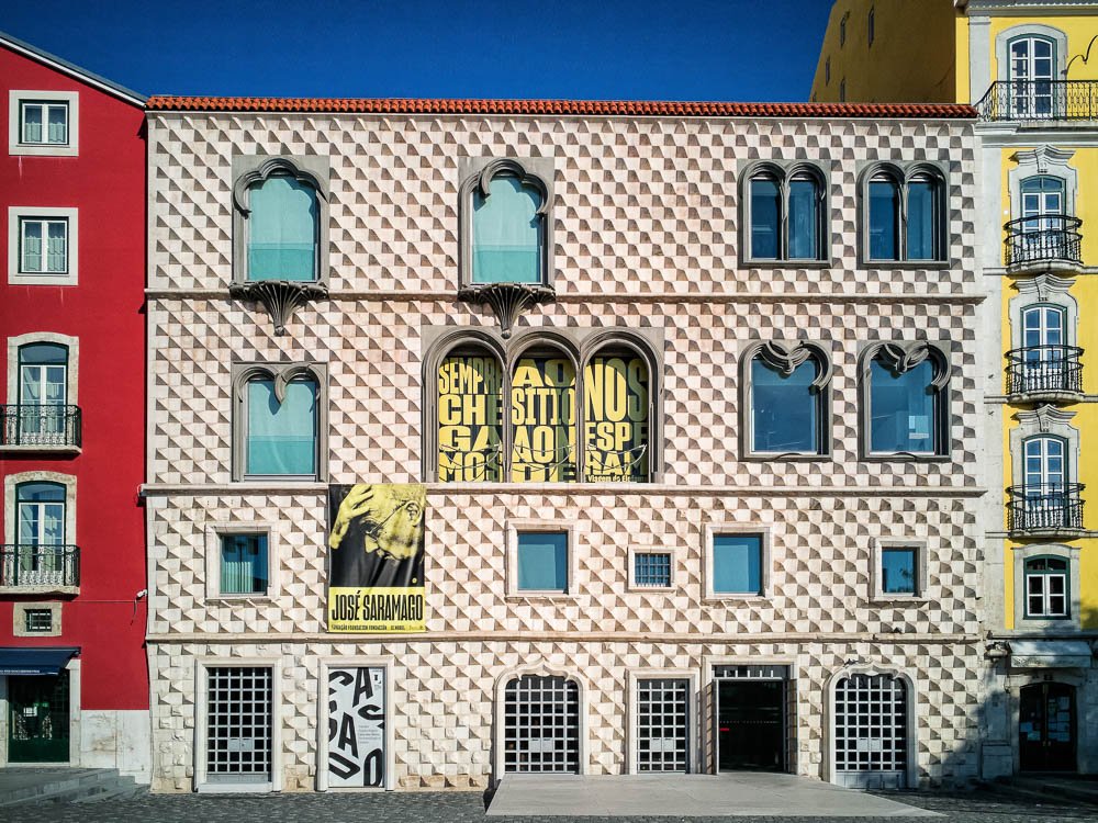 Facade with a banner and geometric stone pattern, captured from a distance.