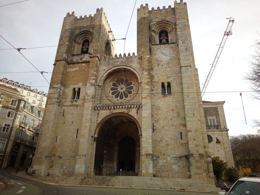 Wide view of the cathedral's main entrance, showing its grand arched doorway and twin towers.