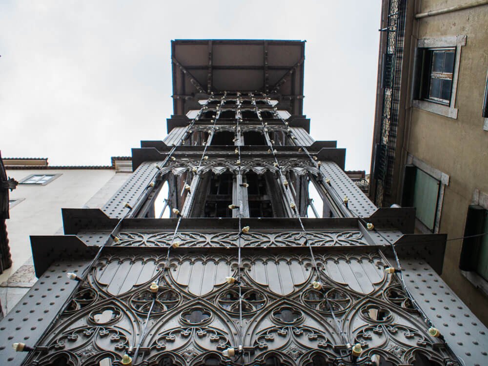 Upward view of the intricate ironwork of the Santa Justa Lift in Lisbon, Portugal.